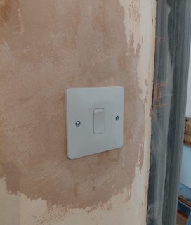 new light switch installed on fresh plaster during house rewire in County Durham